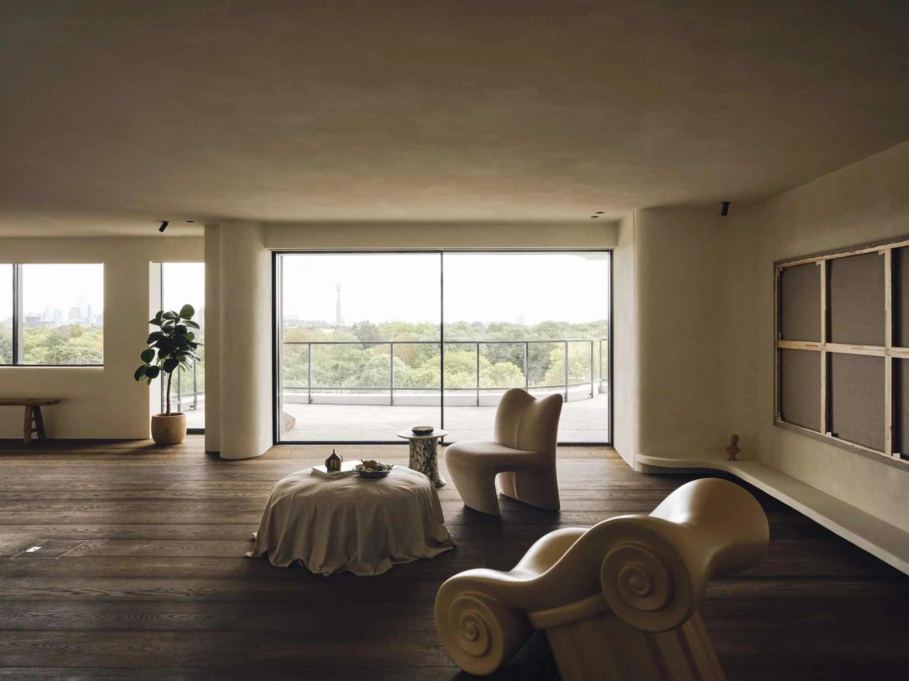 Tom Baddeley residential project: a sunlit living room with sculptural seating and timber flooring